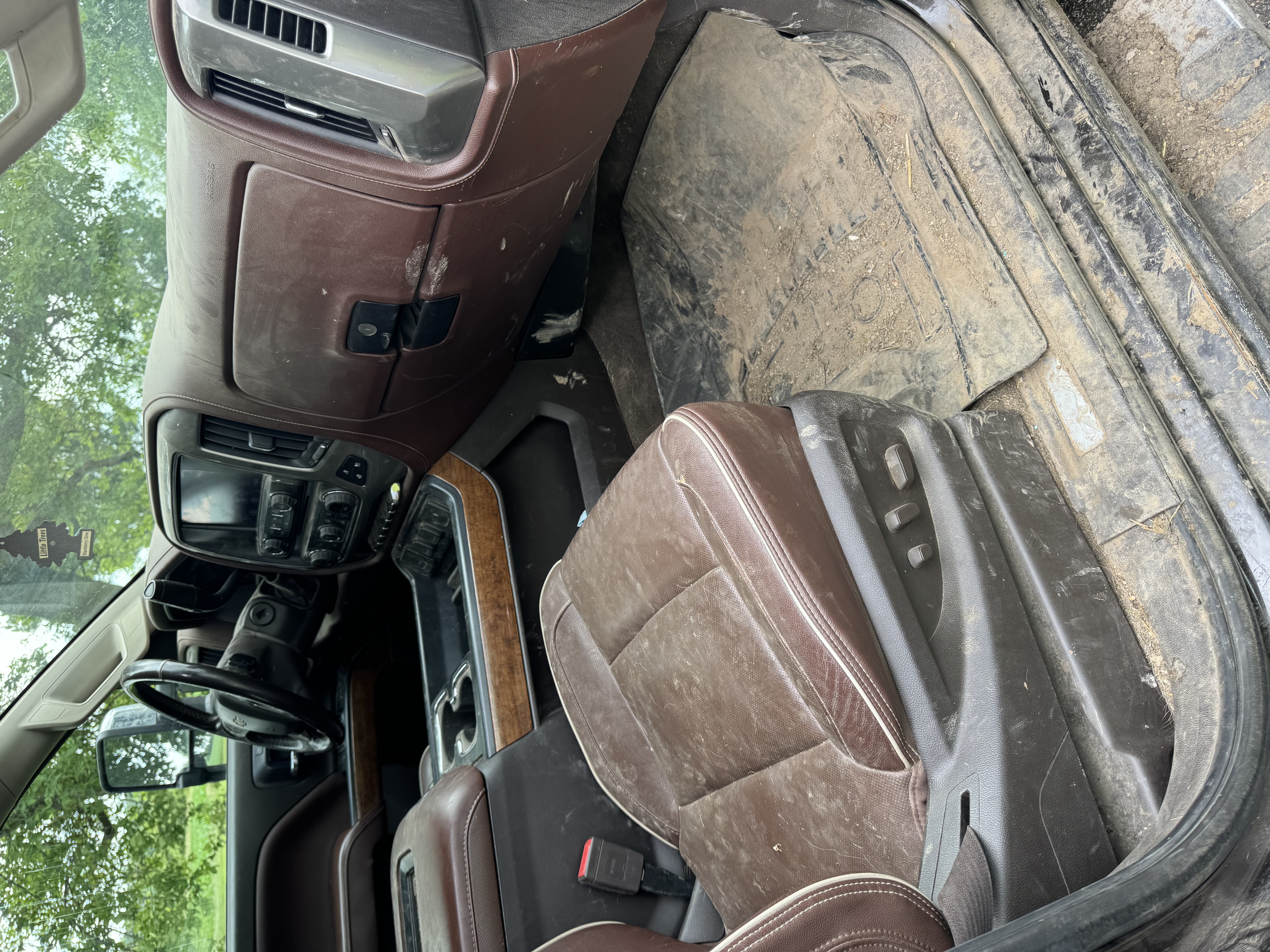 Heavily-worn brown King Ranch leather interior — faded, dirt-streaked seats and a soiled driver's footwell. The kind of cabin condition that knocks thousands off a trade-in appraisal.