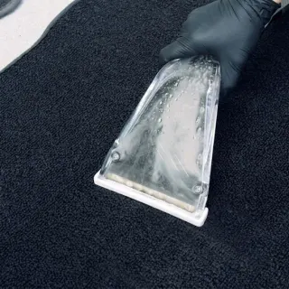 Hot-water extractor pulling embedded dirt out of black carpet during a three-step enzyme carpet extraction by After Hours Car Detailing