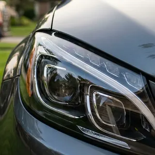 Crystal-clear restored headlight lens on a dark gray car after headlight restoration