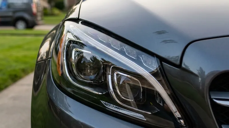 Crystal-clear restored headlight lens on a dark gray car after headlight restoration