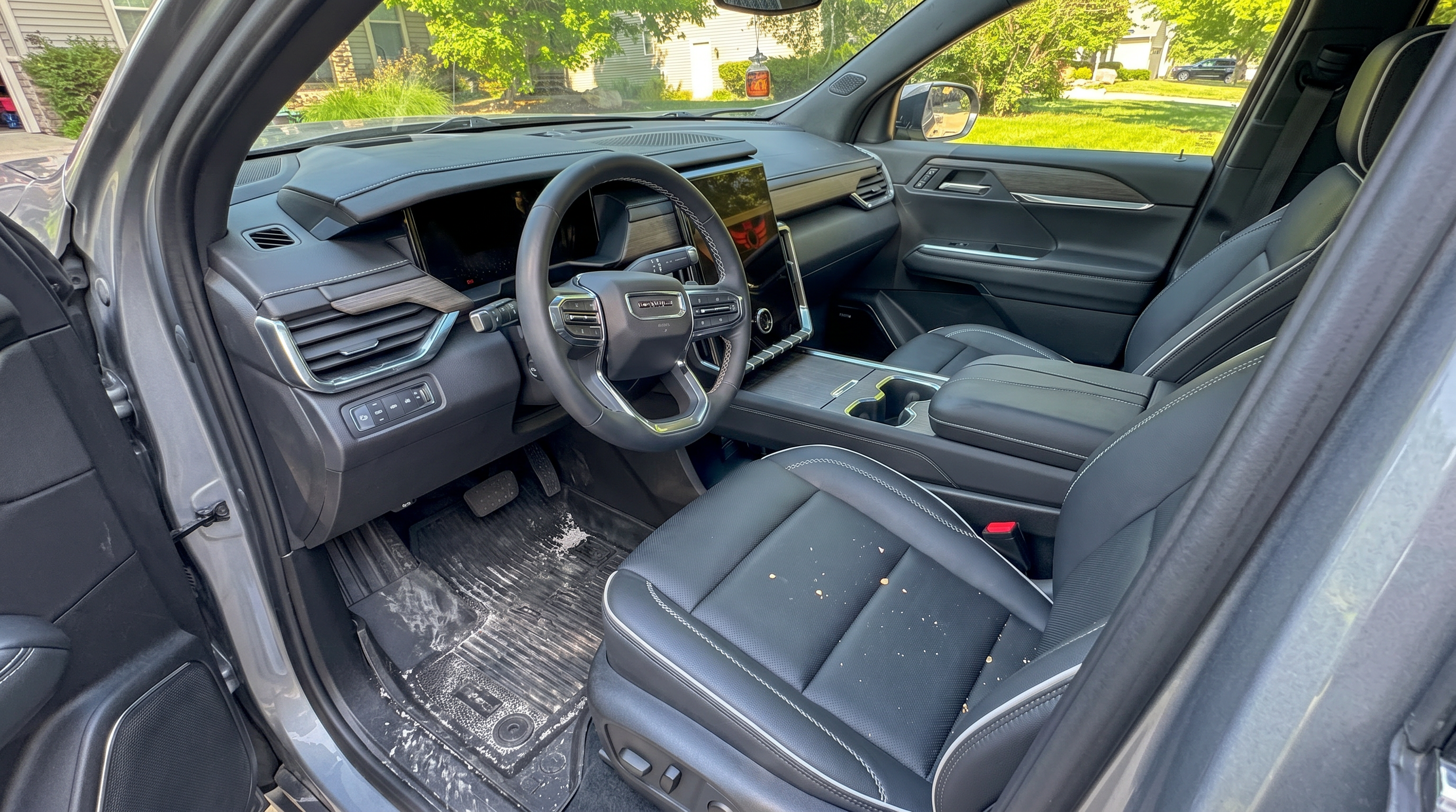 Salt-stained WeatherTech floor mat in a Chevrolet Equinox driver's footwell — gritty winter sand and dried road salt collected in the channels. The Mid-Michigan reality every cabin lives with.